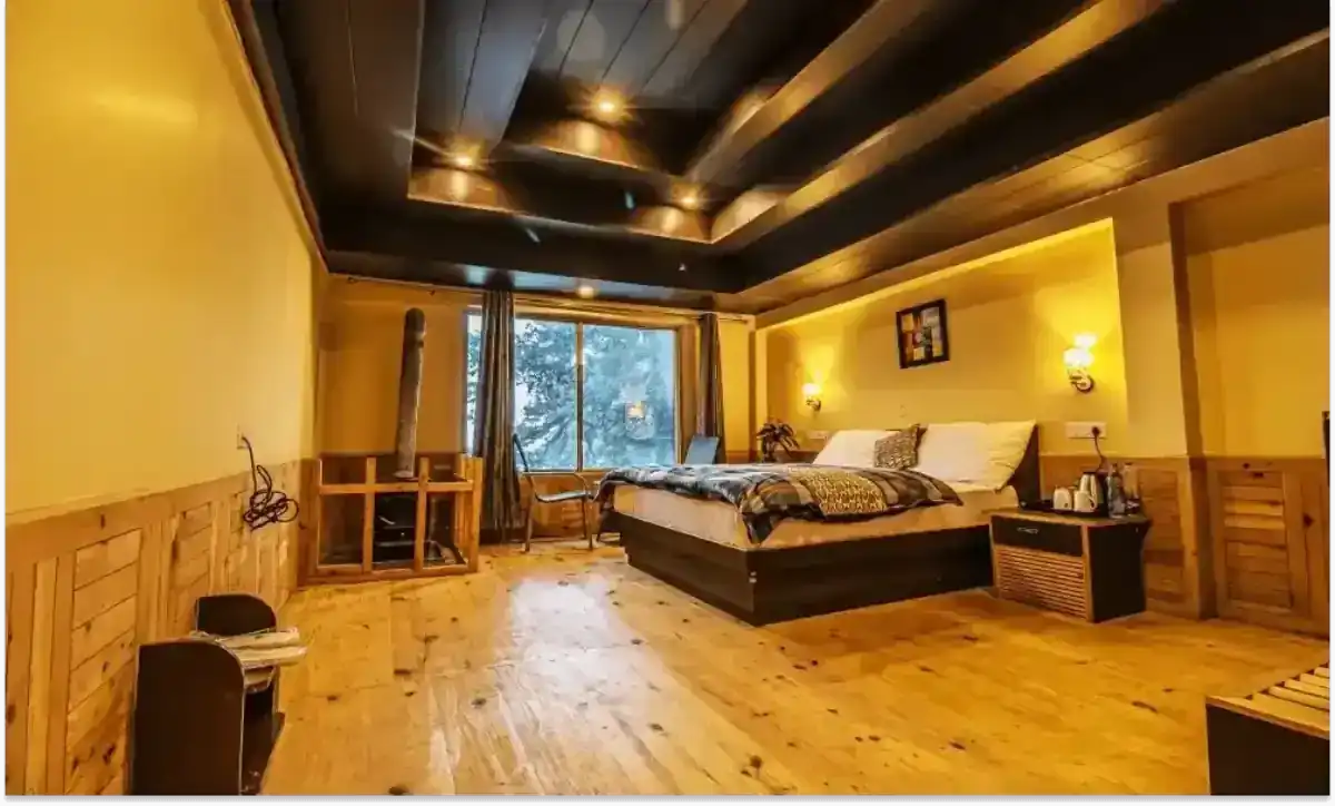Cozy wooden bedroom with a queen bed, fireplace, and large window with snowy view